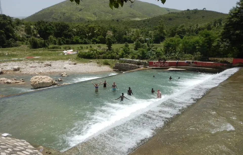 People cooling off in the river at L'Estère beach
